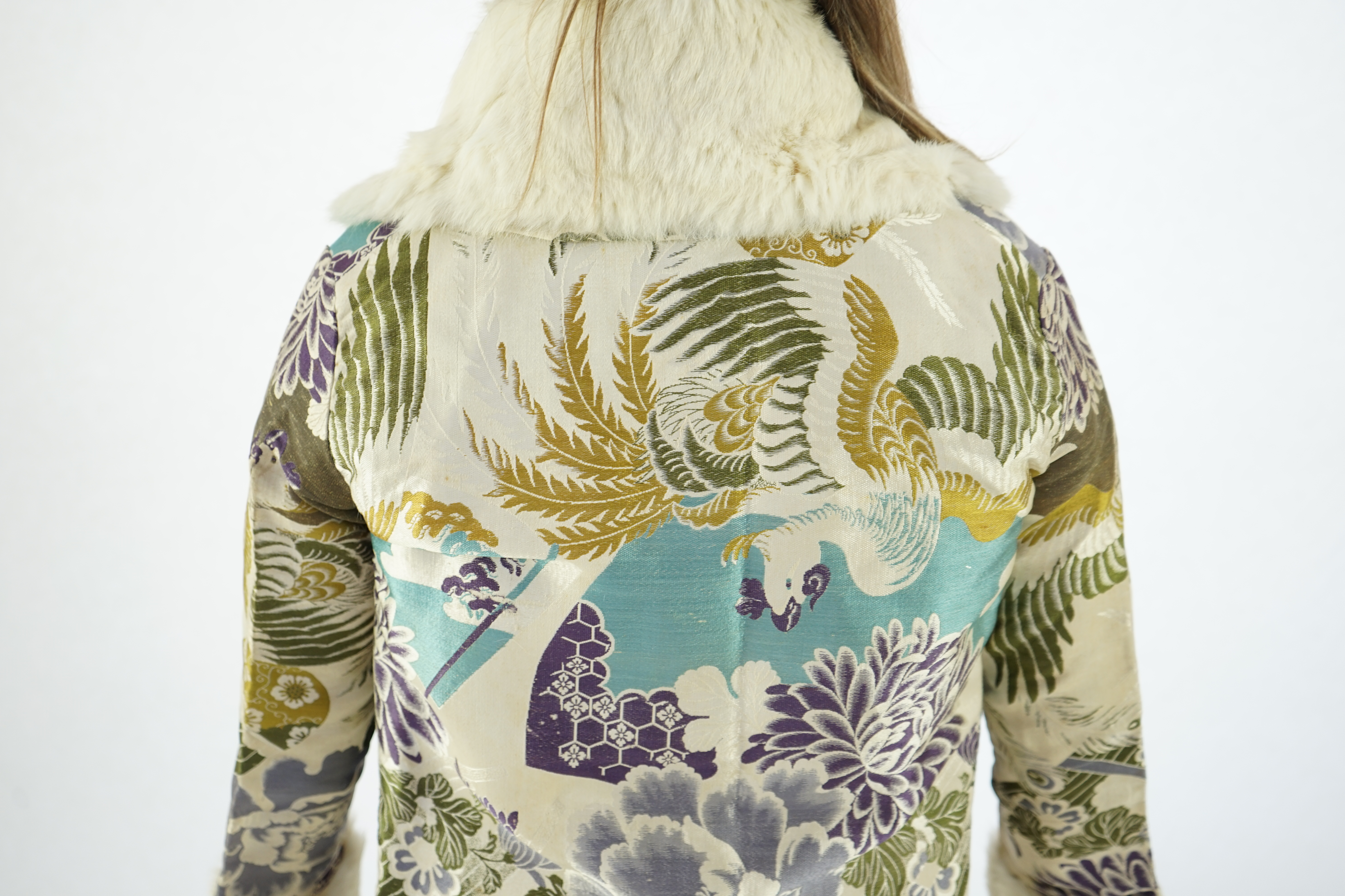 A 1940's lady's patterned brocade evening coat with white fur trim.